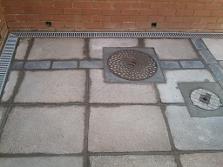 Blue bricks and slabs with manholes and aco drains.